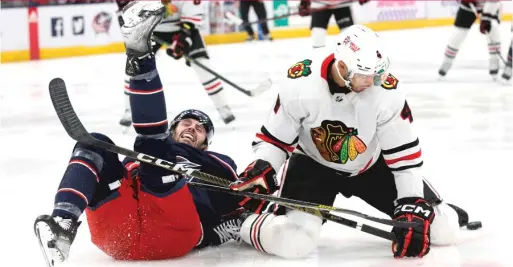  ?? JAY LAPRETE/AP ?? The Blue Jackets’ Liam Foudy and Blackhawks defenseman Seth Jones collide while chasing a loose puck during the second period Saturday.