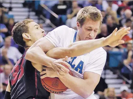  ?? Julie Jacobson Associated Press ?? IN A FIRST HALF DOMINATED by UCLA from the start, the Bruins’ David Wear snares a rebound from Stanford’s Dwight Powell. The Bruins jumped to a 24-5 lead and rolled into the tournament championsh­ip game.