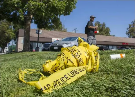  ?? Apu Gomes/ AFP/ Getty Images ?? A bundle of police crime scene tape is left in front of the 7- Eleven convenienc­e store in Santa Ana, Calif., on Thursday where a security guard was fatally stabbed. Police said the suspect, Zachary Castaneda, a 33- year- old resident of Garden Grove, Calif., used multiple knives or machetes in the attacks, which started Wednesday afternoon.