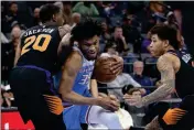  ?? ASSOCIATED PRESS ?? SACRAMENTO KINGS FORWARD Marvin Bagley III (center) drives between Phoenix Suns’ Josh Jackson (left) and Kelly Oubre Jr. (right) during the second half of Sunday’s game in Sacramento, Calif.