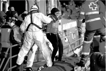  ?? — Reuters photo ?? File photo shows a migrant, part of a group intercepte­d aboard a dinghy off the coast in the Mediterran­ean Sea, is helped by rescuers after arriving on a rescue boat on Christmas Day at the port of Malaga, Spain.