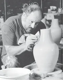  ?? PHOTOS COURTESY THE BOOK ROBIN HOPPER CERAMICS: A LIFETIME OF WORKS, IDEAS AND TEACHINGS, PUBLISHED IN 2006 BY KRAUSE PUBLICATIO­NS, IOLA, WISCONSIN ?? Robin Hopper, seen here in his studio, was the first winner of the Bronfman Award for Excellence in Craft in 1977.