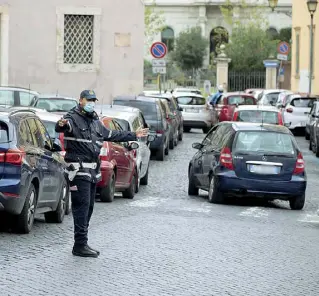  ??  ?? Assalto
Vigili urbani in azione per districare il traffico di auto in attesa per il drive-in del San Giovanni. Al Santa Maria della Pietà la coda era ieri di cinque chilometri (foto Percossi/Ansa)