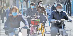  ?? Picture: REUTERS ?? People wear face masks on bikes in Beijing, China.