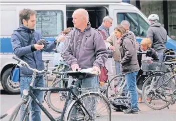  ?? RP-FOTO: OLAF STASCHIK ?? R-Autor und Radler Alexander Riedel (links) im Gespräch mit Hauptkommi­ssar Ralf Billen: Es geht um die richtige Sicherung des Rades.