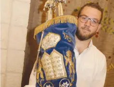  ?? (Courtesy) ?? NOAM FROMOWITZ, a descendant of Yechiel Gordon, with the Gordon family Torah.