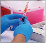  ?? (AP/Mark J. Terrill) ?? A medical worker prepares a flu shot earlier this year at a clinic in Lynwood, Calif., that offered free flu and covid-19 vaccines.