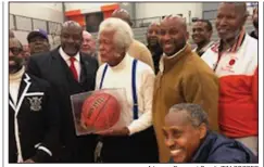  ?? Arkansas Democrat-Gazette/TIM COOPER ?? Former Little Rock Hall coach Oliver Elders poses for pictures with some of his former players Monday after being presented with a signed basketball during a ceremony at the Warriors’ season opener.