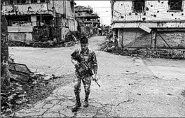  ?? HANNAH REYES MORALES/FOR THE WASHINGTON POST ?? A soldier patrols empty streets Nov. 15, 2017, in Marawi, Philippine­s. Marawi was left in ruins after Islamic State-inspired militants laid siege to the city in a battle that lasted months.