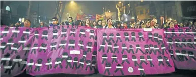  ??  ?? Demonstrat­ors hold a banner covered in black ribbons representi­ng murdered women as they protest against gender violence.