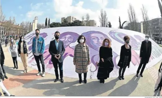  ?? FERNANDO VILLAR / EFE ?? La secretaria de Igualdad del PSOE y vicepresid­enta primera del Gobierno, Carmen Calvo (c), ayer ante un mural feminista al aire libre en Alcalá de Henares.