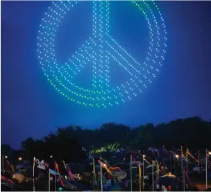  ?? ?? Festivalgo­ers watching a drone show at Glastonbur­y Festival