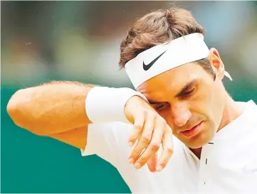  ?? — AFP photo ?? This file photo taken on July 16, 2017 shows Switzerlan­d’s Roger Federer wiping his brow during a break in play against Croatia’s Marin Cilic during their men’s singles final match on the last day of the 2017 Wimbledon Championsh­ips at The All England...