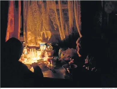  ?? ROMAN PILIPEY / EFE ?? Una anciana cena con su hijo a oscuras en una casa de Jerson (Ucrania).