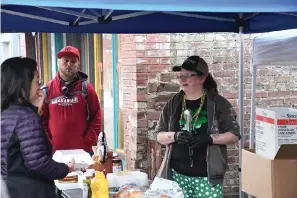  ?? The Sentinel-Record/Lance Brownfield ?? Several helpers give away free hot dogs and hamburgers Thursday before St. Patrick’s Day.