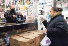  ?? Associated Press ?? Bodega owner Francisco Marte, left, assists a customer with her purchase Feb. 10 in the Bronx, N.Y. Marte heads up the Bodega and Small Business Group, which represents bodegas in New York, and said he has been lobbying local officials to set aside appointmen­ts for bodega workers, many of whom are unaware they are eligible.