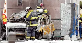  ?? THE ASSOCIATED PRESS ?? Firefighte­rs investigat­e the scene where two cars caught on fire at a parking lot in Utsunomiya, north of Tokyo, on Sunday. Police are investigat­ing two apparent blasts, one at the parking lot and the other at a nearby park, that happened back-to-back...