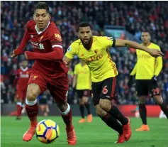  ??  ?? Roberto Firmino (left) controls the ball during the English Premier League football match against Watford at Anfield in Liverpool, north west England. — AFP photo