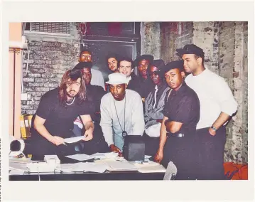  ??  ?? TOP: Long Island’s Public Enemy signs with Def Jam Recordings’ Rick Rubin (far left) in 1986. LEFT: Lead rapper Chuck D performs at a New York concert in 1988. His tour with Prophets of Rage hits New York in late July.