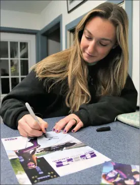  ?? DANIELLE RAY / SENTINEL & ENTERPRISE ?? Drag racer Britt Taylor signs autographs at her racing team's home base, Renegade Rides on River Street in Fitchburg.