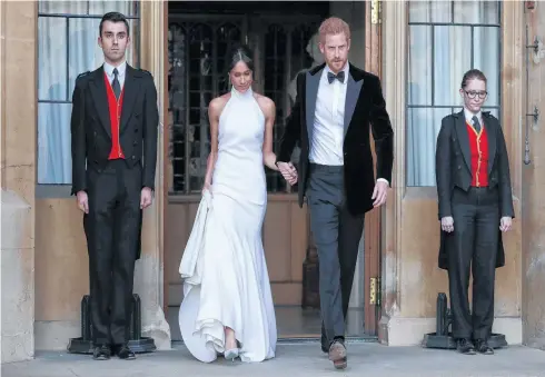  ?? STEVE PARSONS AP ?? The newly married Duke and Duchess of Sussex, Meghan Markle and Prince Harry, leave Windsor Castle after their wedding in Windsor, England, to attend an evening reception at Frogmore House, hosted by the Prince of Wales on Saturday. •