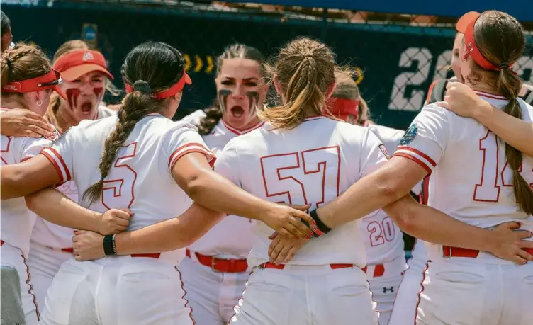  ?? STAN GROSSFELD/GLOBE STAFF ?? The Utah softball players got themselves psyched up for a game against the University of Washington at the Women’s College World Series in Oklahoma City.