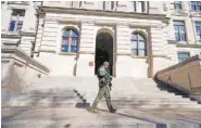  ?? (AP PHOTO/JOHN BAZEMORE ?? A Georgia State Patrol guard patrols outside the Georgia Capitol on Friday in Atlanta.