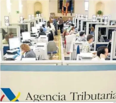  ?? EFE ?? Funcionari­os atienden a contribuye­ntes en una sede de la Agencia Tributaria.