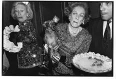  ?? Dafydd Jones via The New York Times ?? Iris Love, left, and Brooke Astor react as their dogs, Just Desserts and Polly, tangle over canapes at a dog party in February 1990 at the Barberra restaurant in New York City.