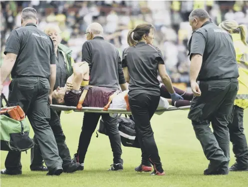  ??  ?? Agony for Hearts captain Christophe Berra as he is stretchere­d off during Saturday’s victory over Celtic with a torn hamstring.