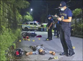  ?? MIGUEL DE GUZMAN ?? Police officers gather evidence at the scene of an alleged shootout between two suspected robbers and police officers along Road 10 in Project 6, Quezon City before dawn yesterday.