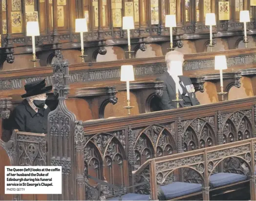  ?? PHOTO: GETTY ?? The Queen (left) looks at the coffin of her husband the Duke of Edinburgh during his funeral service in St George’s Chapel.