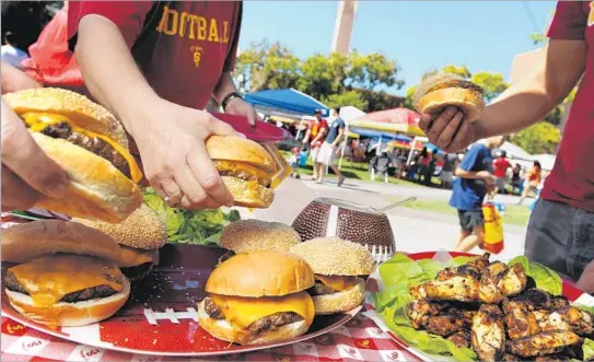  ?? Wally Skalij
Los Angeles Times ?? THE GAME PLAN
at a USC tailgater called for burgers and chicken wings prepared ahead to just get slapped on the grill, so everyone had plenty of time to party.