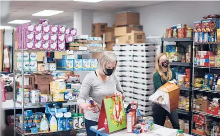  ?? TRAVISDOVE/THENEWYORK­TIMES ?? AprilReibe­stein, left, a volunteer at theArmed ServicesYM­CAat Fort Bragg, prepares orders at a food bank on the base.