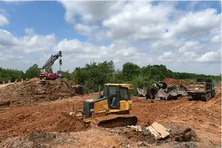  ?? Staff photo by Jerry Habraken ?? Members of Cleve Batte Constructi­on Inc. work Friday on building a new culvert on Miller County Road 64 after the old one collapsed last month.