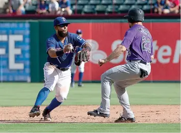  ?? AP Photo/Sam Hodde ?? Texas Rangers second baseman Rougned Odor, left, tags out Colorado Rockies' Tom Murphy (23) during the eighth inning of a baseball game Saturday in Arlington, Texas.