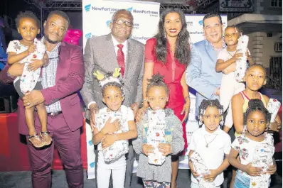  ?? CONTRIBUTE­D ?? It was an evening of lights, cheer and beautiful memories for kids in Sam Sharpe who attended the Annual Christmas Tree Lighting Ceremony recently. In the photo from L-R are Heroy Clarke, MP for St. James Central, Hon. Jeffrey Pitkin, Custos of St. James, Verona Carter, VP, Public Affairs, New Fortress Energy and Mayor of Montego Bay, Councillor Homer Davis, posed with a few of the kids who attended the Ceremony. Thanks to New Fortress Energy Foundation, more than one thousand kids in the second city received a toy for Christmas.