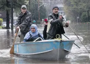  ?? PIERRE OBENDRAUF ?? Tauseef Bhatti, front, and wife Weena Sehar journey to their flooded house on Jean-Yves St. in Île-Bizard last May.