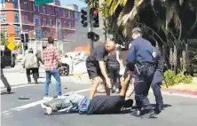  ?? Courtesy Barbara Llarena ?? Police and bystanders drag alleged pimp Michael Brown from a burning car in Emeryville on Sunday after a fatal crash.