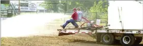  ?? MARK HUMPHREY ?? Members of the Lincoln Riding Club spray down the rodeo arena.