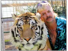  ??  ?? The irrepressi­ble Joe Exotic poses with a friend in a photograph used in the Netflix documentar­y miniseries Tiger King: Murder, Mayhem and Madness.