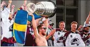  ?? JACK DEMPSEY / AP ?? Colorado Avalanche left wing Gabriel Landeskog hoists the Stanley Cup and a flag of Sweden at a rally for the NHL champions Thursday in Denver.