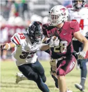  ?? OKLAHOMAN] [PHOTO BY ALONZO ADAMS, FOR THE ?? Tuttle’s Jon-Michael Hollarn (28) runs ahead of Hilldale’s Dylan Walker (33) during Friday’s high school Class 4A football playoff game in Tuttle.