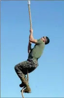  ??  ?? A MARINE NEARS THE TOP OF THE ROPE CLIMB (above) while another clears one of several hurdles (top left) during the Obstacle Course Relay event. Marines carry a loaded stretcher, ammo cans and five-gallon containers filled with water (left) during the Casualty Evacuation Relay event.