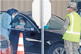  ?? SUSANSTOCK­ER/SOUTHFLORI­DASUNSENTI­NEL ?? Health careworker­s assist people withCOVID-19 testing at the HardRockSt­adium drive-thru site onTuesday in Miami Gardens.