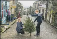  ?? PICTURES: TONY JOHNSON. ?? TREE TIME: Main, Ian Park, chair of the Christmas in Haworth committee, trims a tree with his wife Diane on Main Street; above left, volunteers Anthony Hartley and Barry Foster lend a hand and, right, shop owners Karen Lynch and Clare Austin decorate their tree.