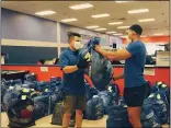  ?? ALIAH KIMBRO — THE MORNING JOURNAL ?? Lorain Boys and Girls Club director Adrian Sanchez and Jahleel Moon, staff, prepare bags of clothing for distributi­on.