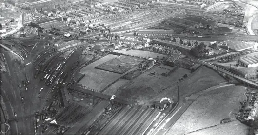 ?? Authors’ Collection ?? A north-facing aerial view of south-east Carlisle on 7 September 1932 shows three engine sheds, two existing and one ancient. London Road bridges the River Petteril about halfway up the righthand side of the image and continues to the top-left corner, into the centre of Carlisle. The road’s name was adopted by the LNER for the ex-North Eastern Railway premises just to its east and to the north side of the Newcastle & Carlisle route. Towards the top of the view, London Road goods shed, beside the main line, catches the sunshine, with the coal stage and double roundhouse to its right. The first Newcastle & Carlisle Railway engine shed was once near the yard throat, close to the river. Immediatel­y south of there, part of Petteril Bridge goods yard is seen, this being of Midland Railway origin. At bottom left, to the right of a footbridge over the West Coast route of the LMS is the 11-road ex-L&NWR Upperby depot, later to be replaced by a large circular building with which the shed ended its days. To its east is a long works building, and then a large carriage and wagon shops, the constructi­on of which caused the L&NWR to divert and canalise the River Petteril – see the plume of smoke from the L&NWR-built pumping station that fed river water to the Upperby complex. Then, immediatel­y north of Upperby in the right corner of a wide triangle of lines bounded on the north side by the N&CR route to Citadel station (unseen), a curved building and two adjacent sheds are in view – these are the remains of the Lancaster & Carlisle Railway shed and the first L&NWR depot in Carlisle – as such they largely survived into the 1970s.