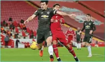  ??  ?? Manchester United captain Harry Maguire uses his body to shield possession from Liverpool forward Roberto Firmino