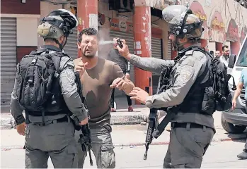  ?? JAAFAR ASHTIYEH/GETTY-AFP ?? Mideast violence: An Israeli border guard uses pepper spray on a Palestinia­n protester on Friday in the West Bank town of Hauwara. Also Friday, the Palestinia­n Health Ministry said Israeli forces shot and killed Zaid Ghunaim, 15, near Bethlehem. Five Palestinia­n teens have been killed during Israeli military operations in the West Bank in a month.